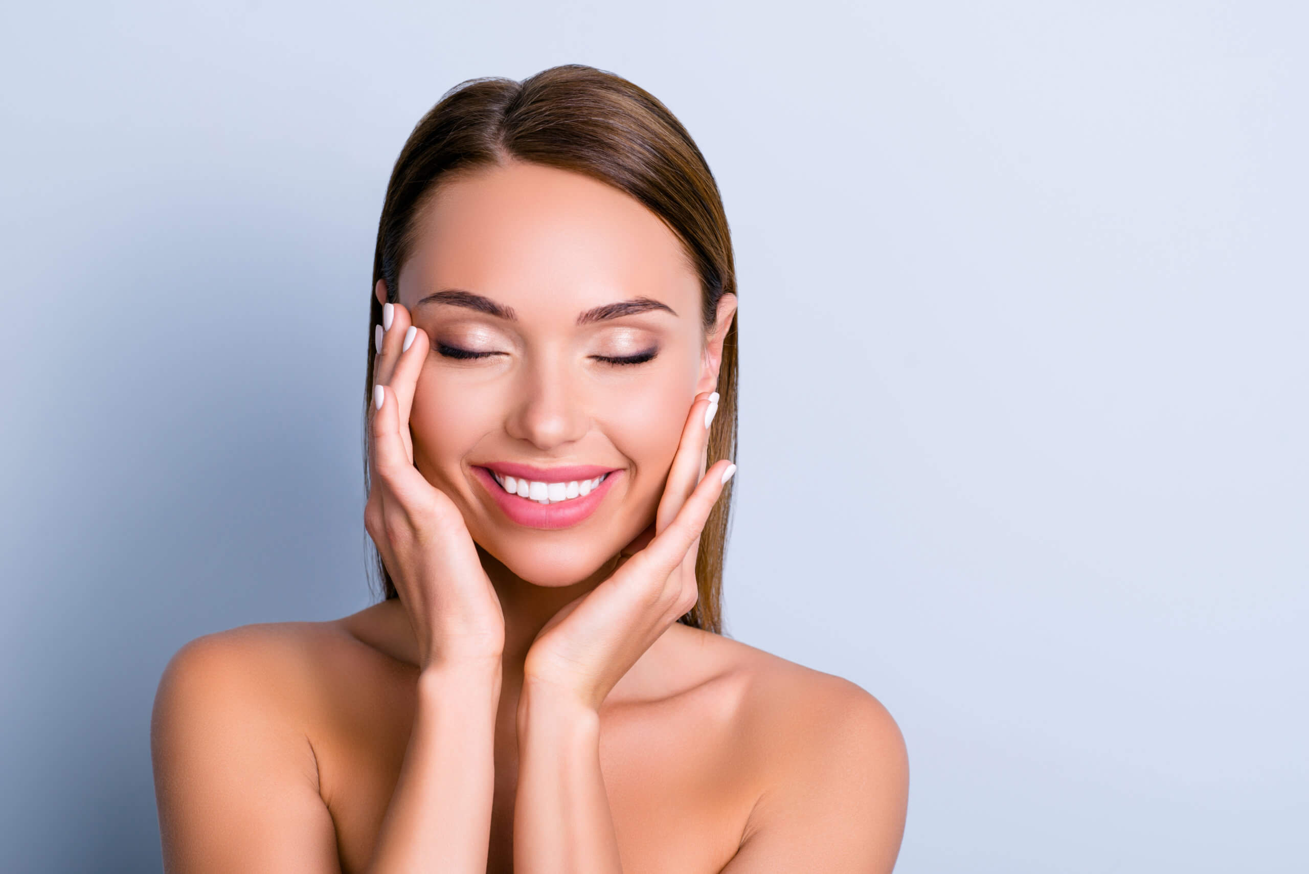 Portrait of pleased satisfied girl touching face enjoying | Gig Harbor Aesthetics in Gig Harbor, WA